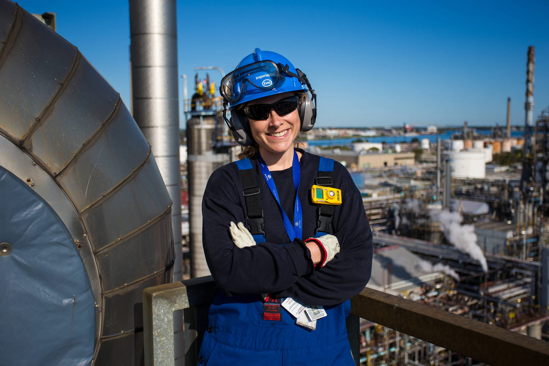 Trabalhadora com capacete e protetor auricular em uma planta industrial