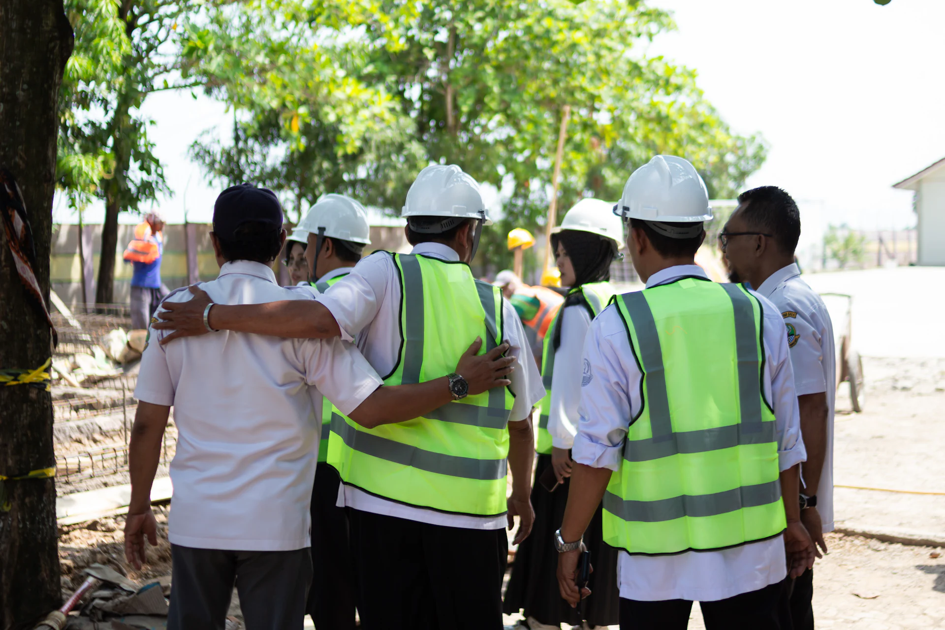 Equipe com capacetes e coletes de segurança em um canteiro de obras