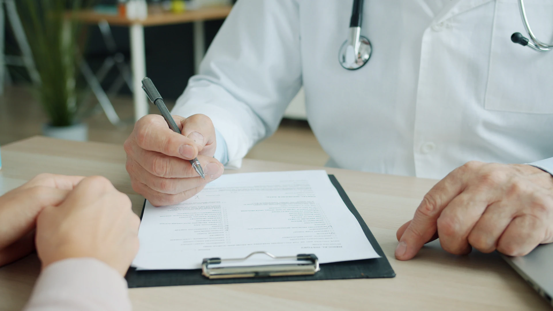 Médico do trabalho preenchendo o prontuário de um paciente